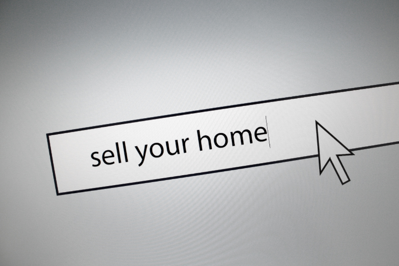 A computer screen displays a search bar with the words sell your home being typed, and a large arrow cursor pointing at the text.