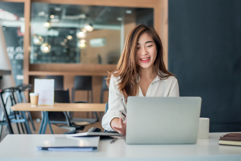 Charming asian businesswoman sitting working on laptop